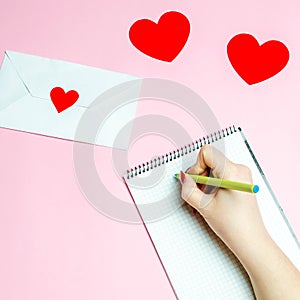 Girl writes a love letter. Valentines day concept. Greeting valentine card. Declaration of love. Wedding invitation. Red hearts.