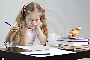 The girl writes on a piece of paper sitting at the table in the image of the writer