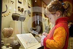 Girl writes to writing-books at excursion