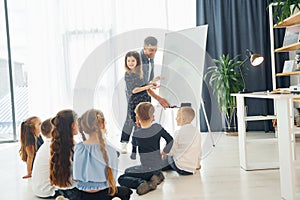 Girl writing on the board. Group of children students in class at school with teacher