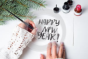 Girl writing Happy new year calligraphy card