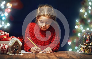 Girl is writing the letter to Santa