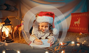 Girl is writing the letter to Santa