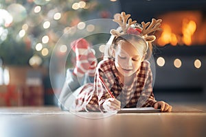 Girl is writing the letter to Santa