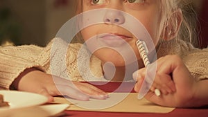 Girl writing letter to Santa Claus, dreaming of Christmas miracle, closeup