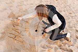 Girl Writing New Year in Sand