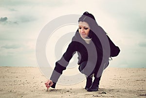 Girl writing in the sand