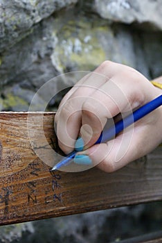 Girl writing on wood bench