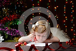 Girl wrote in red pencil a letter to Santa Claus