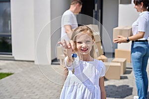 Girl in the yard with keys to a new house