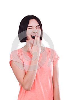 A girl yawns, covering her mouth with her hand. Isolated on white background.