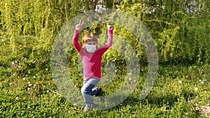 Girl 6 years old in a long sleeve fuchsia or hot pink. The child wears a white protective surgical mask. Prevention of airborne