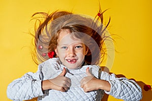 The girl on the yellow background. No front teeth. Tooth fairy and dentistry.Smiles happy. Thumbs up, cool