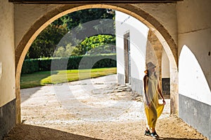 A girl in a yellow dress at an old house.Tourist