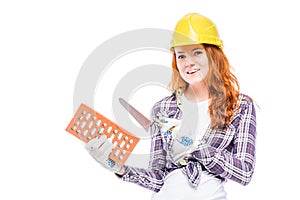 Girl in a yellow hard hat with a brick building builder