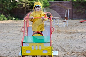 Girl in yellow raincoat on playground