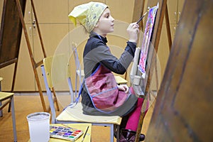 Girl in yellow scarf and apron painting colorful photo