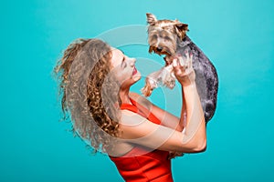 Girl with yorkie dog. Beauty young girl in red dress hug her sweet yorkshire terrier isolated on green background