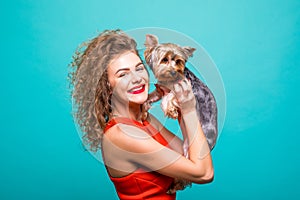 Girl with yorkie dog. Beauty young girl in red dress hug her sweet yorkshire terrier isolated on green background
