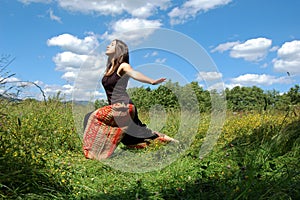 Girl/young woman doing a yoga pose outdoors in a natural environment