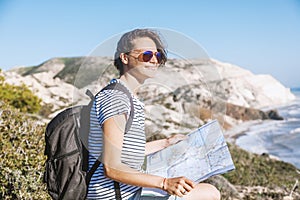 Girl young woman traveler with a backpack and map in hand walks
