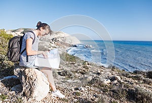 Girl young woman traveler with a backpack and map in hand walks