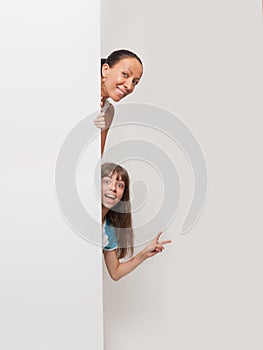 Girl and young woman beside a white blank