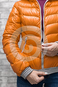 girl zips up her bright down jacket