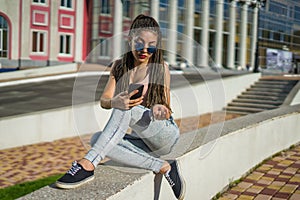 Girl with zizi cornrows dreads chatting on her smartphone