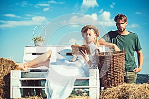 Girlfriend and boyfriend date outdoor. Woman bride in wedding dress relax on bench. Sensual woman read book for man