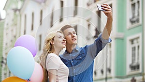 Girlfriend and boyfriend hugging in street and taking selfie, romantic photos