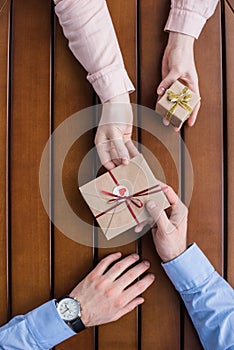 Girlfriend gifting postcard in envelope and present box to boyfriend