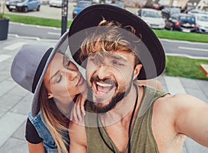 Girlfriend kissing boyfriend while he is taking selfie