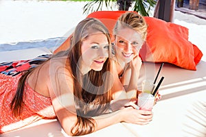 Girlfriends in beach bar drinking cocktails