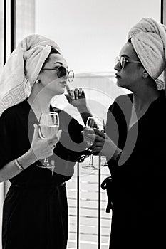 Girlfriends are celebrating the bride& x27;s bachelorette party. Two women in robes, sunglasses and towels on their heads are