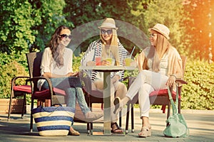 Girlfriends enjoying cocktails in an outdoor cafe, friendship concept