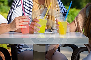 Girlfriends enjoying cocktails in an outdoor cafe, friendship concept