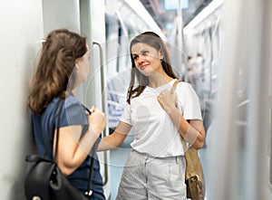 Girlfriends enjoying conversation in subway train