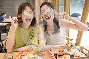 Girlfriends Enjoying Fresh Salad in Restaurant and Having Fun