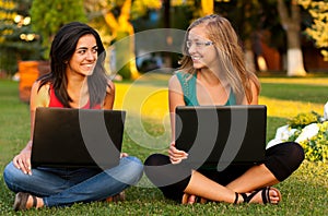 Girlfriends with laptops sitting photo