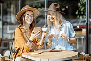 Girlfriends spending time together on a cafe terrace