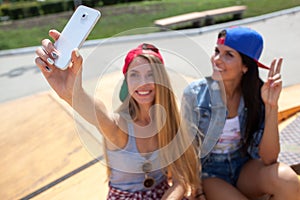 Girlfriends taking a selfie photo on the skate park