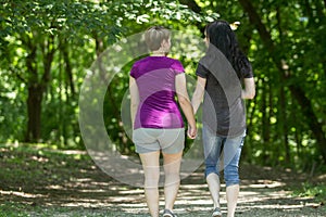 Girlfriends taking a walk through the park, horizontal