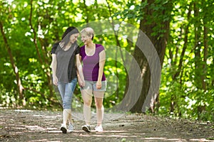 Girlfriends taking a walk through the park, horizontal