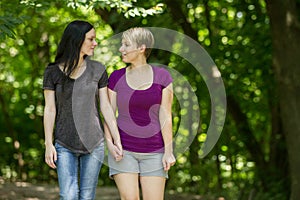 Girlfriends taking a walk through the park, horizontal