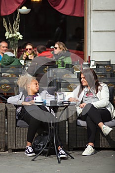 Girlfriens talking sitting in the outdoor coffee bar, Trieste