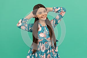 Girlhood dream. Relaxed girl blue background. Happy child smile putting hands behind head. Girlhood photo