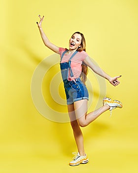 Girlish, funky, happiness, dream, fun, joy, summer concept. Very excited happy cute girl is jumping up, in summer outfit