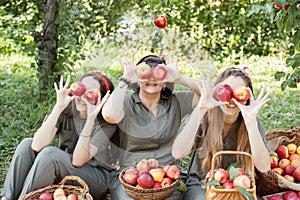 Girls with Apple in the Apple Orchard. Beautiful sisters with Organic Apple in the Orchard. Harvest Concept. Garden, teenagers