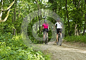 Girls from backside biking in the forest photo